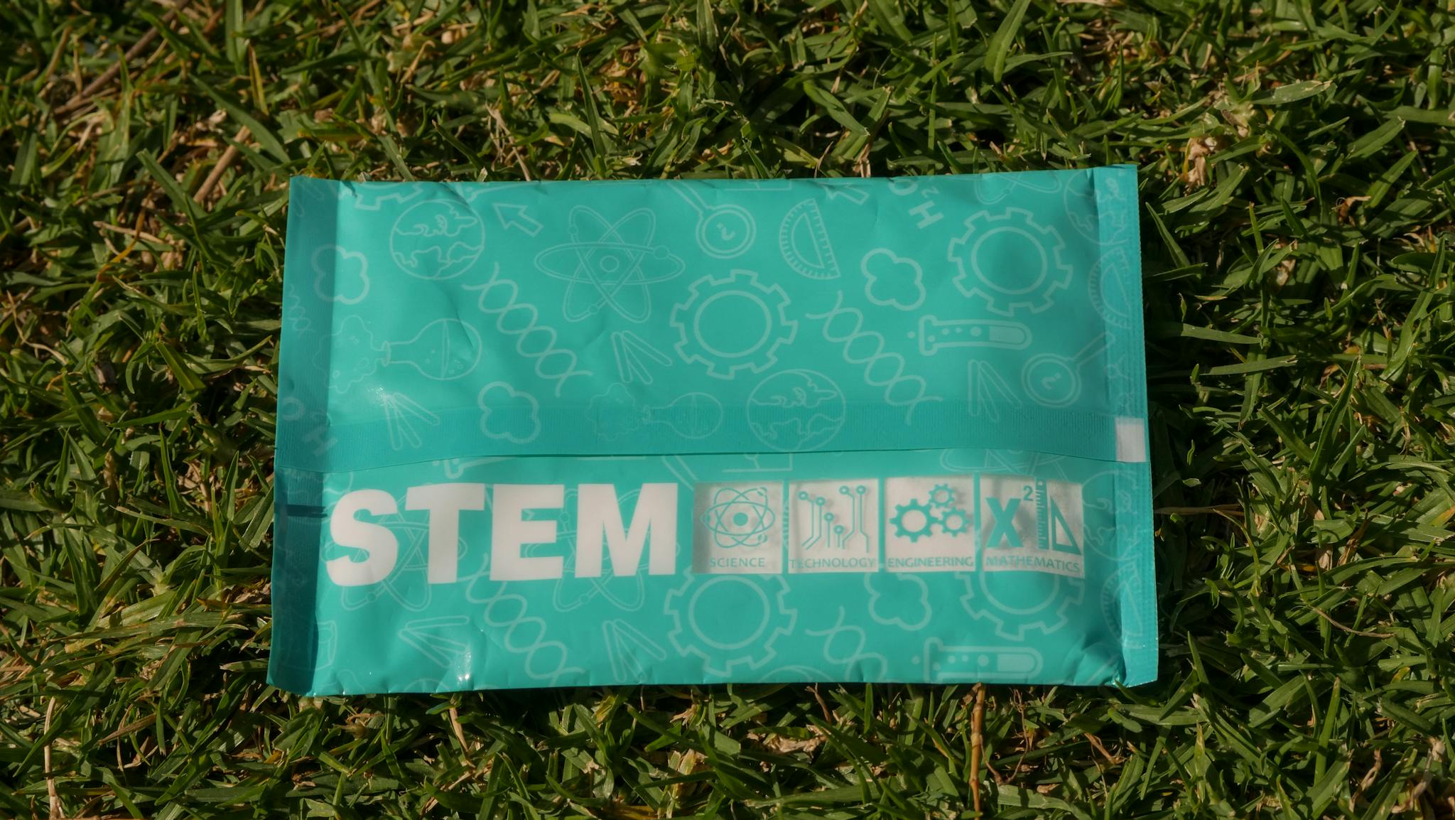 STEM-themed bag on grass promoting science, technology, engineering, and math.